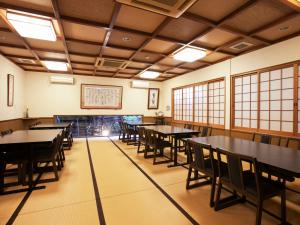 a dining room with tables and chairs and windows at Oyado Yumechidori in Saga
