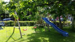 un parque infantil con un tobogán en un árbol en Balkonwohnung Norderney, en Hooksiel