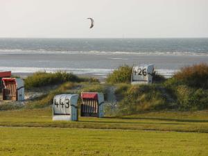a group of huts on the side of a beach at Balkonwohnung Leuchtturm in Hooksiel +30 photos
