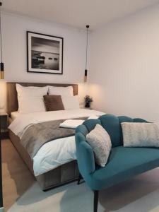 a bedroom with a bed and a blue couch at Premium Hils Brauner Studio in Bucharest +43 photos