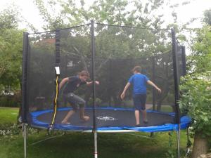 Dos hombres están jugando en un trampolín en Balkonwohnung Roter Sand, en Hooksiel