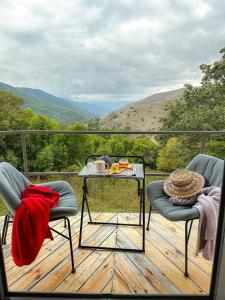 einen Tisch und zwei Stühle auf einer Terrasse mit Aussicht in der Unterkunft Nature Rooms-Cozy Cabin in the Woods 