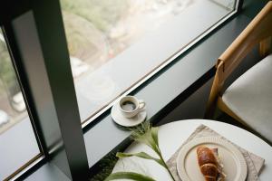 Una mesa con un plato de comida y una taza de café. en Urbanstay Myeongdong, en Seúl
