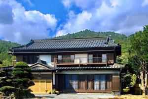 忍野村的住宿－民宿富島 Tomijima Hostel-Traditional japapnese whole house with view of mt fuji - Oshino Hakkai，一座日式房子,背景是一座山