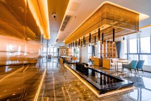 Yunmu Hotel Luzhou في لوزهاو: لوبي فندق فيه طاولات وكراسي