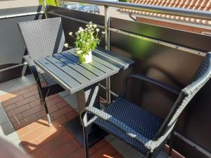 einen Tisch und einen Stuhl auf einem Balkon mit einer Pflanze in der Unterkunft Balkonwohnung Seestern in Hooksiel