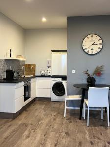 a kitchen with a table and a clock on the wall at Nyibaer studio apartment in Selfoss