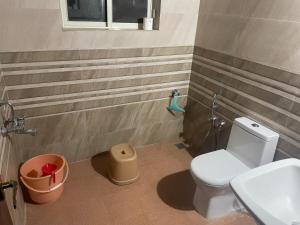 a bathroom with a toilet and a sink at Menlha Wellness Resort in Kushālnagar