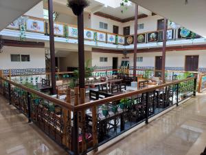 a restaurant with tables and chairs in a building at Menlha Wellness Resort in Kushālnagar