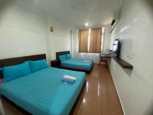 a room with two beds and a tv in it at UMMUL MOTEL CMART in Arau
