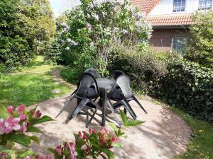 two birds sitting on a table in a garden at Helle Balkonwohnung Spiekeroog in Hooksiel
