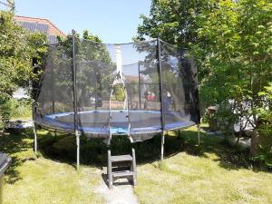 a trampoline with a chair in a yard at Helle Balkonwohnung Spiekeroog in Hooksiel +40 photos