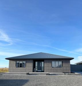 a house with a black roof on a street at Nyibaer studio apartment in Selfoss