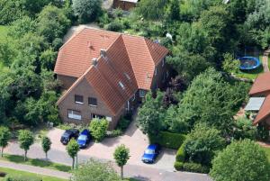 una vista aérea de una casa con coches aparcados en una entrada en Terrassenwohnung Langeoog, en Hooksiel