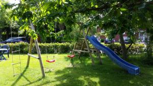 un parque infantil con un tobogán en un árbol en Terrassenwohnung Langeoog, en Hooksiel