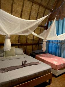 a bedroom with two beds and a mosquito net at Lanta Marina Resort By Mam&Mod in Ko Lanta