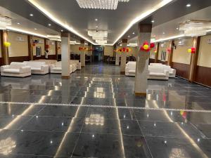 een lobby met witte banken en tafels in een gebouw bij THE SKYLITE HOTEL & BANQUET in Ara