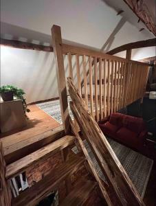 a wooden staircase in a room with a red couch at Cozy Cottage with hot tub! in Cadnam