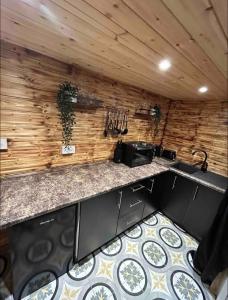 a kitchen with a counter top and wooden wall at Cozy Cottage with hot tub! in Cadnam