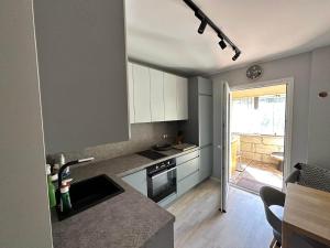 a kitchen with white cabinets and a counter top at Tihase Vindi Accommodation in Tallinn