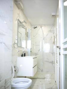 Baño blanco con aseo y lavamanos en Best Studio Central, en Hunedoara