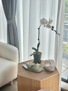 a table with a flower on it next to a window at Hidden Hotel in Dali