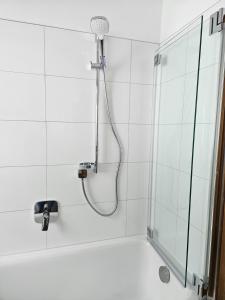 La salle de bains est pourvue d'une douche avec un pommeau de douche. dans l'établissement Ferienhaus Birnberg, à Leogang