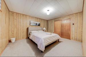 a bedroom with a large bed and wooden walls at The Cozy Nook House in Ajax