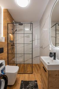 ein Bad mit einer Dusche, einem WC und einem Waschbecken in der Unterkunft Vip Apartamenty Niecia z klimatyzacja in Rzeszów