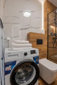 a washing machine with towels on top of it in a bathroom at Vip Apartamenty Niecia z klimatyzacja in Rzeszów