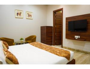 a bedroom with a large bed and a flat screen tv at The Royal Casa Hotel, Ludhiana in Ludhiana