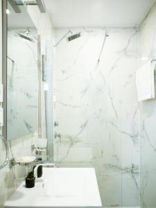 y baño blanco con lavabo y ducha. en Best Studio Central, en Hunedoara