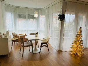 une salle à manger avec une table et un sapin de Noël dans l'établissement Appartement calme et lumineux de 2,5 pces proche Lausanne, à Ecublens