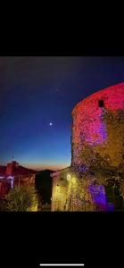budynek z czerwonymi i fioletowymi światłami w obiekcie La “Torre dell’amore” w mieście Moricone