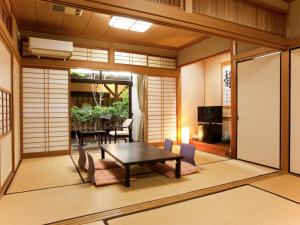 a room with a table and chairs and a dining room at Oyado Yumechidori in Saga