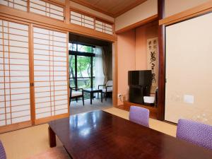 a dining room with a wooden table and purple chairs at Oyado Yumechidori in Saga