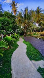 a walkway in a garden with palm trees at Wooden House on lake,city center in Luang Prabang