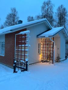 a small building with snow on the ground at Nordic Apartment Katajaranta in Rovaniemi