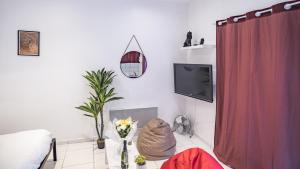 - un salon avec un lit et une télévision dans l'établissement Smart Confort 3 - Studio confort et stylé, à Troyes