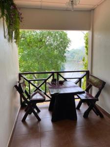 a table and chairs on a balcony with a view of a river at Saiyok River House in Sai Yok