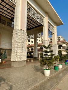 a large building with palm trees in front of it at Flamingo Hotel Sector 67 I Studio Rooms I Gurgaon in Gurgaon