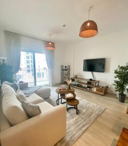 sala de estar con sofá blanco y TV en Yas Island canal 1- Formula 1, Entertainment, and Luxury Living!, en Abu Dabi
