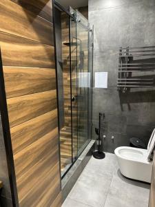 een badkamer met een douche, een toilet en een wastafel bij ЖК Falcon City in Alma-Ata