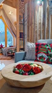 una grande ciotola di legno piena di decorazioni natalizie su un divano di Lux Houses w DOMKU tylko DWA APARTAMENTYz jacuzzi zewnętrznym a Groń