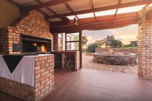 an outdoor patio with a fireplace and a fire pit at Temba Private Game Reserve in Grahamstown