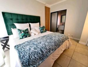 a bedroom with a large bed with a green headboard at The Blyde Crystal Lagoon in Pretoria