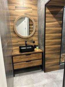 een badkamer met een wastafel en een spiegel bij ЖК Falcon City in Alma-Ata