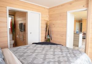 a bedroom with a bed in a room with wooden walls at Bever Farm in Waitoki