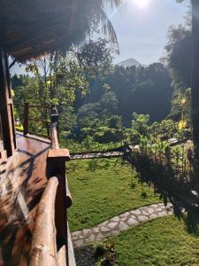 un balcón de una casa con vistas a un campo en Dreamy Eco Tree House by 7 Waterfalls en Ambengan