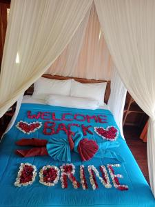 a bed with a blue comforter with flowers on it at Dreamy Eco Tree House by 7 Waterfalls in Ambengan